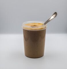 In a plastic cup are vegetable puree and a teaspoon