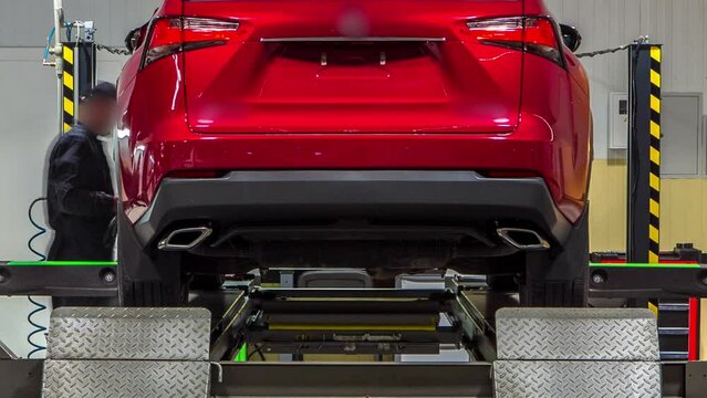 Car on stand with sensors on wheels for wheels alignment camber check in workshop of Service station timelapse. Car moves on lift