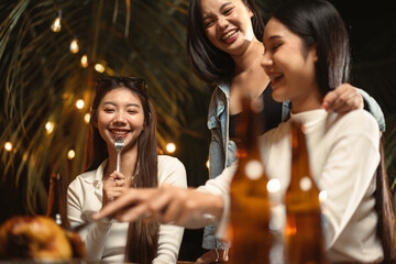 Happy young Asian woman dinner party celebrating with her friends at night. Friendship and celebration concept.