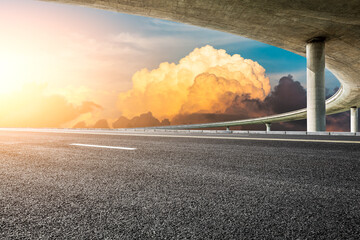 Asphalt road and Bridge with beautiful clouds at sunset