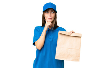 Young beautiful caucasian woman taking a bag of takeaway food over isolated background having...