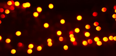 Blurred yellow Bokeh of light on dark or black background. Lighting blurry wallpaper. Festival and Celebration concept. 