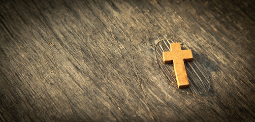 Christian cross on the wooden background.