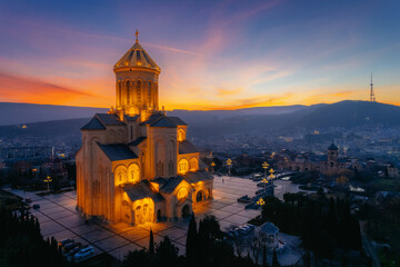 Aerial skyline with downtown district and Holy Trinity church dome or Tsminda Sameba Cathedral at sunset, Tbilisi, Georgia - 554893097