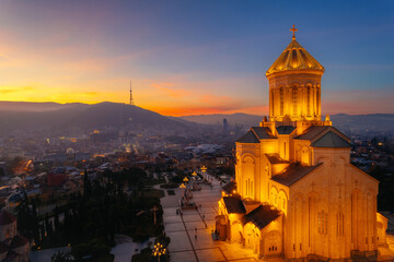 Aerial skyline with downtown district and Holy Trinity church dome or Tsminda Sameba Cathedral at sunset, Tbilisi, Georgia - 554893222