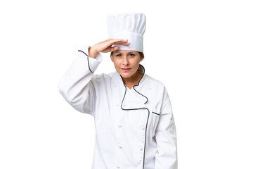 Middle-aged chef woman over isolated background looking far away with hand to look something