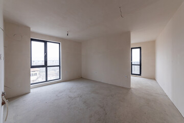 New empty room under construction. Plaster walls. New home. Concrete walls. Interior renovation.