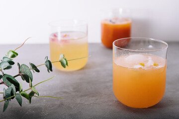 pineapple and carrot juices in glass with cubes Ice