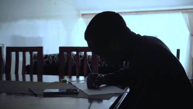 silhouette of a young man drawing