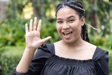 Happy smiling young African woman pointing up 5 fingers, showing number five, fifth point or giving...