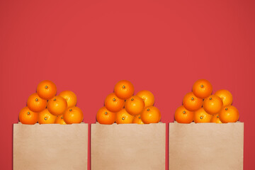Oranges in a paper bag. On a red background.
