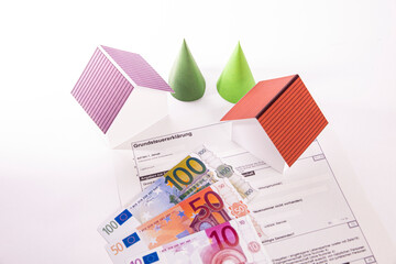 Grundsteuerformular mit zwei Häusern und Euroscheinen