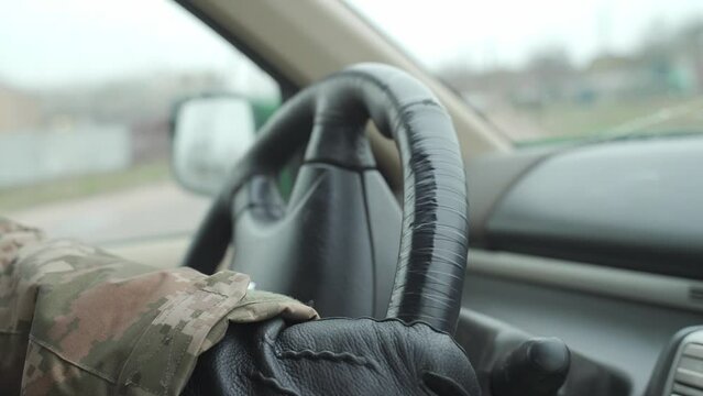 Ukrainian military man in uniform and leather gloves drives a car, close-up. transportation in the army. the use of pickup trucks for military purposes. military evacuation