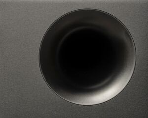 Detail modern subwoofer, closeup, audio speaker. Circle membrane sound speaker on black background