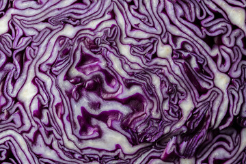 Background of blue cabbage in a section, macro photography. Closeup, top view. Texture and pattern of raw purple cabbage