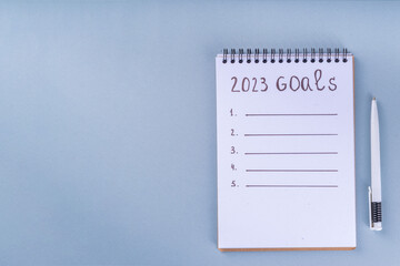  Simple background with Notebook with New's Year Resolutions massage. New Year goals List 2023, plan listing of new year beginnings goals, resolutions setting. Flat lay copy space 