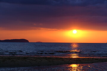 Fototapeta na wymiar 父母が浜の水平線に沈む夕陽