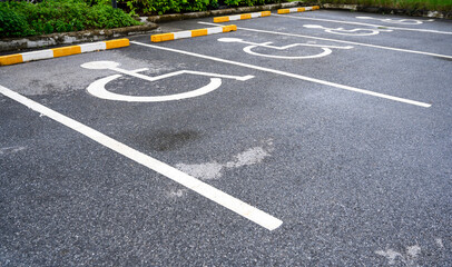 White handicapped symbol painted on asphalt floor special lane parking. Disabled parking spaces. traffic sign about handicaps.