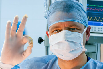 Portrait of male surgeon showing ok sign.