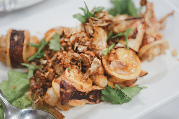 Deep fried squid with garlic decorate with fried garlic and coriander. Thai style seafood, appetizer seafood