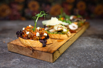assorted bruschetta with different flavors on a wooden board