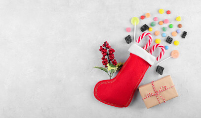 Red Epiphany Befana's stocking with sweet coal and candy on light gray background, Italian Epiphany...