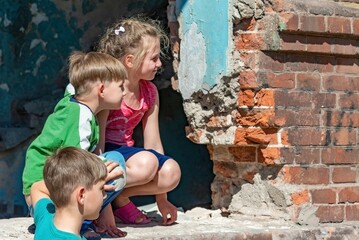Three children in a destroyed house are hiding from military conflicts, refugee children have...