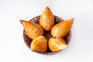 five pieces of samsa in a basket with tomato sauce on a white background