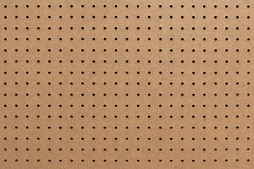 Abstract background of brown perforated hardboard sheet, Plywood with pre-drilled with evenly...