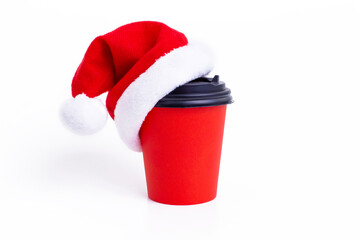 Obraz na płótnie Canvas Red paper cup with red Santa Claus cap