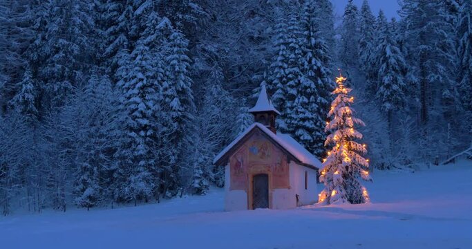 Beleuchteter Weihnachtsbaum mit Kapelle bei Nacht, Winterlandschaft, Bayern, Deutschland