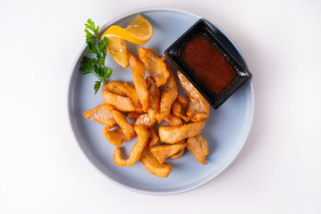 fried fish with tomato sauce on a white background