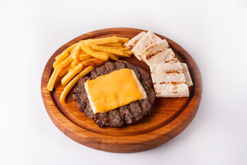 steak with cheese and French fries on a round wooden board. on a white background