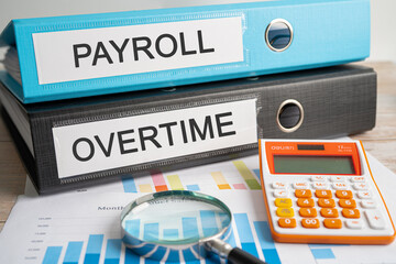 Payroll, Overtime. Binder data finance report business with graph analysis in office.