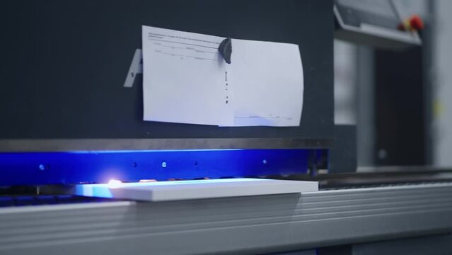 automated woodworking process, worker puts chipboard detail in edge banding machine, closeup