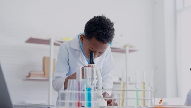 4K, school boy, Wearing white glue shirt, in science class, in order able use in real-life chemistry experiments in science class, Use your hand on turntable to enlarge object, wear white glue shirt.