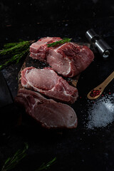 Raw pork steak on the bone on a wooden table. Cooking meat