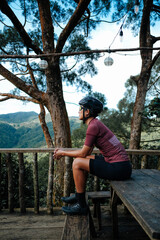 Fototapeta premium A young female cyclist looking at a view in the mountains during her bike ride.