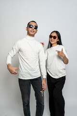 Young couple wearing white blank shirt doing a cool pose with a white background