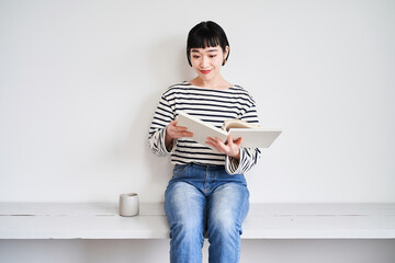 部屋で読書する若い女性