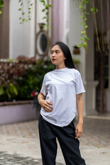 A young woman with a white blank shirt doing a cool pose with the with out of focus background