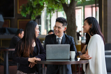 Asian business man and woman or partnership using laptop computer discussing project work in the office work space