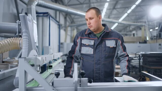 laborer is working in workshop of modern furniture factory, portrait of adult man in uniform