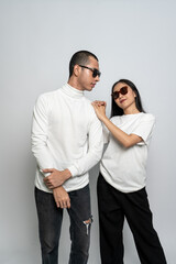 Young couple wearing white blank shirt doing a cool pose with a white background