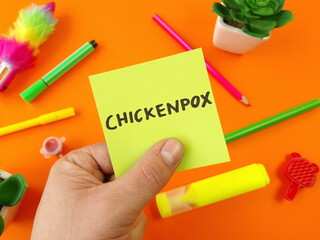 Word chickenpox on sticky note with colorful child supplies. Health care concept