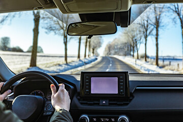 man driving a car on an winter road. Close-up of hands on a steering wheel. view from the driver's back.
