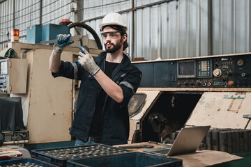Industrial engineers inspect and perform maintenance on the machines at factory machines.