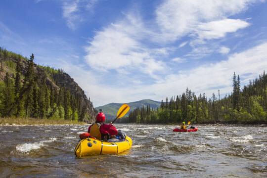 Two women packrafters negotiating a tributary of the Charley River in summertime, Yukon&ndash;Charley Rivers National Preserve; Alaska, United States of America