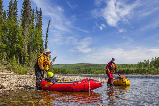 Two women packrafters getting ready to launch on the Charley River in summertime, Yukon&ndash;Charley Rivers National Preserve; Alaska, United States of America
