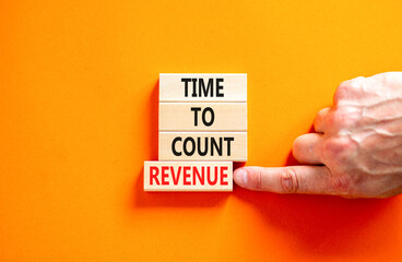 Time to count revenue symbol. Concept word Time to count revenue on wooden blocks. Businessman hand. Beautiful orange table orange background. Business and time to count revenue concept. Copy space.